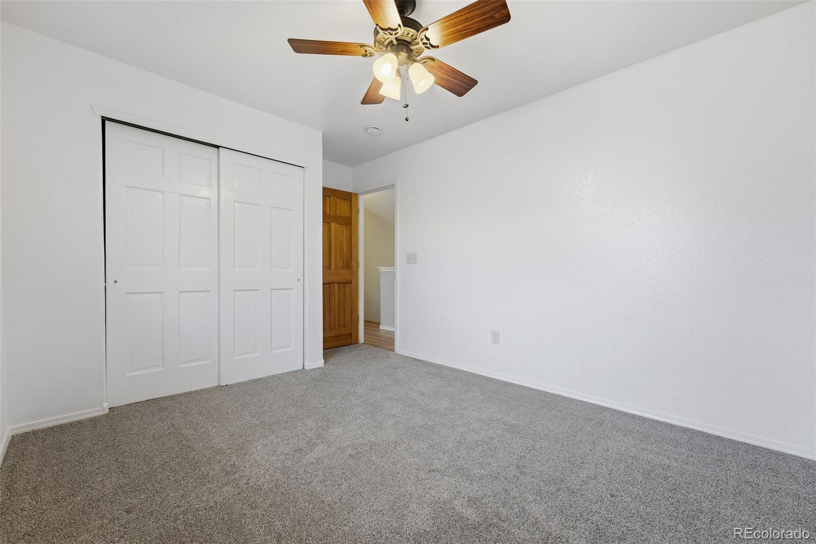 6471 St Vrain Ranch Boulevard Firestone, CO 80504 - Photo 37 of 45 an empty room with closet and a chandelier fan
