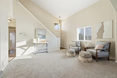 a living room with furniture and a table and a large window