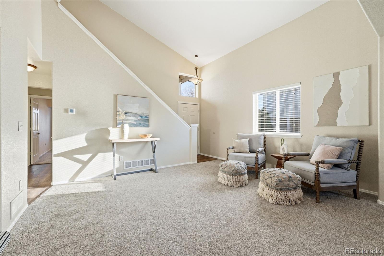 6471 St Vrain Ranch Boulevard Firestone, CO 80504 - Photo 8 of 45 a living room with furniture and a table and a large window