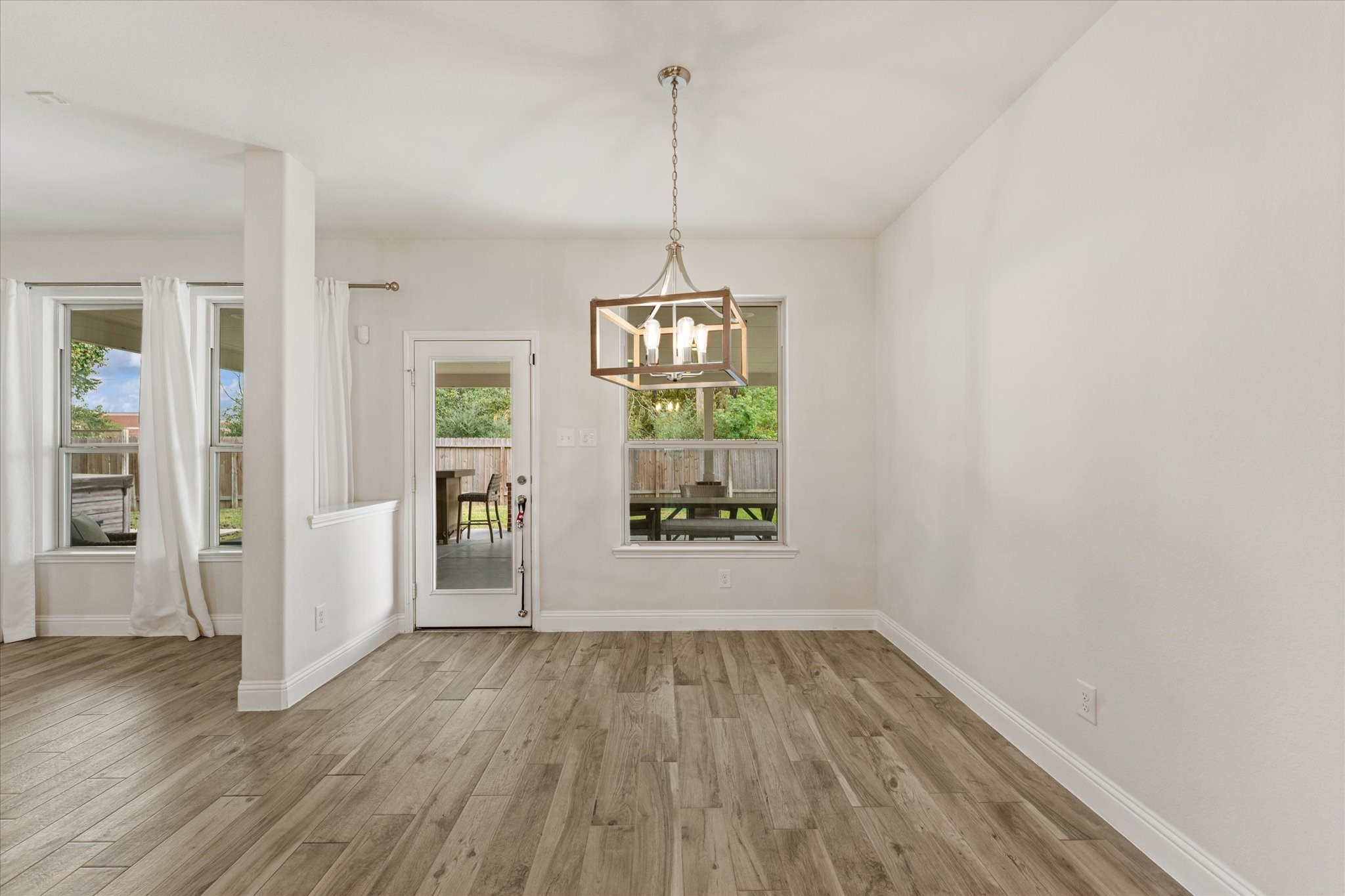 3402 Dryer Park Drive Spring, TX 77373 - Photo 14 of 40 Bright dining area with a modern chandelier, and large windows providing ample natural light.