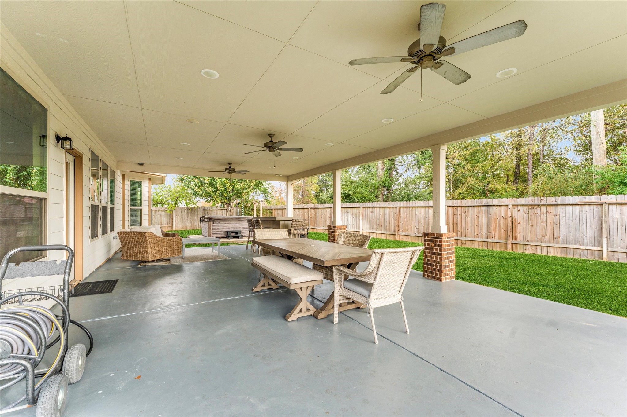 3402 Dryer Park Drive Spring, TX 77373 - Photo 33 of 40 Oversized covered patio with ceiling fans, ideal for outdoor dining and relaxation. Oversized lot, providing a private and inviting atmosphere.