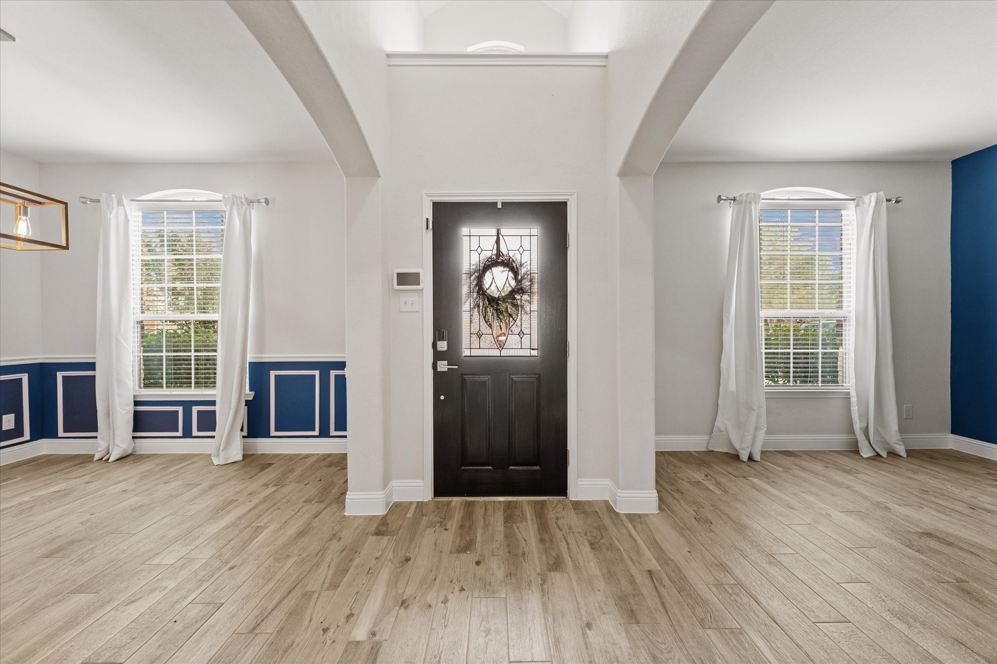 3402 Dryer Park Drive Spring, TX 77373 - Photo 5 of 40 The room features wood-look flooring and a stylish blue and white color scheme with wainscoting, creating a welcoming atmosphere.