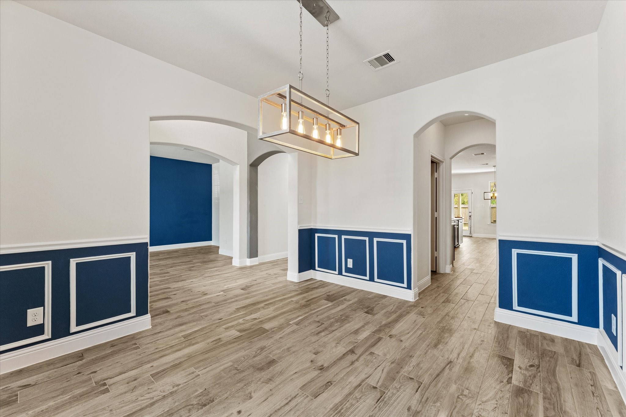 3402 Dryer Park Drive Spring, TX 77373 - Photo 9 of 40 Bright dining area with elegant wainscoting, featuring a modern pendant light fixture.