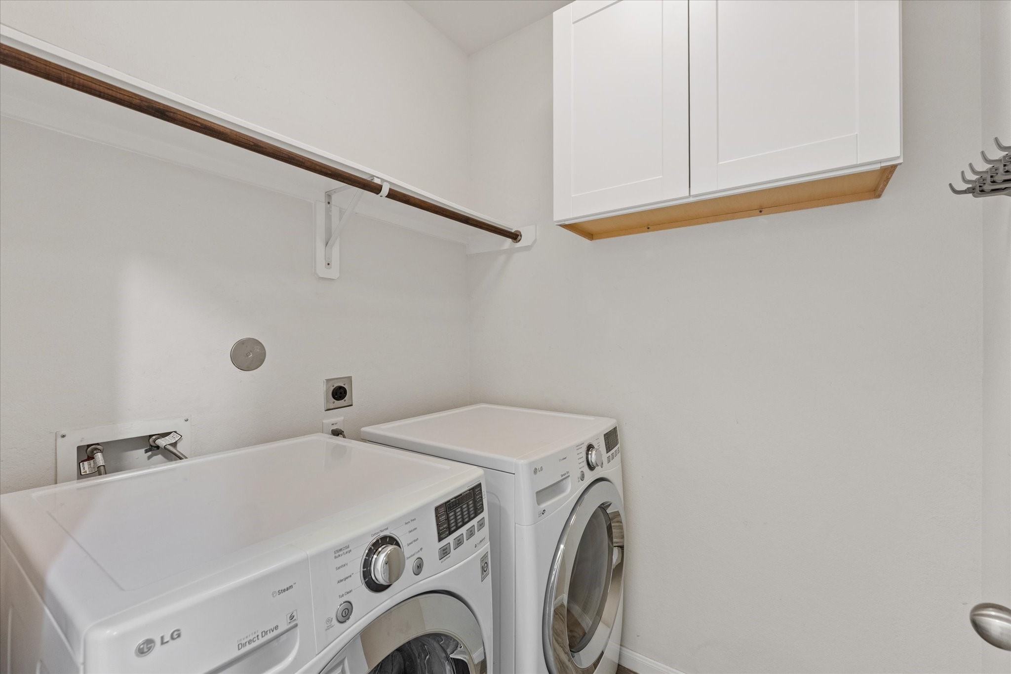 3402 Dryer Park Drive Spring, TX 77373 - Photo 10 of 40 Laundry room equipped with modern LG washer and dryer. It features overhead white cabinetry for storage and a hanging rod for convenience.