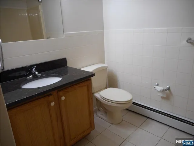 a bathroom with a granite countertop sink toilet and mirror