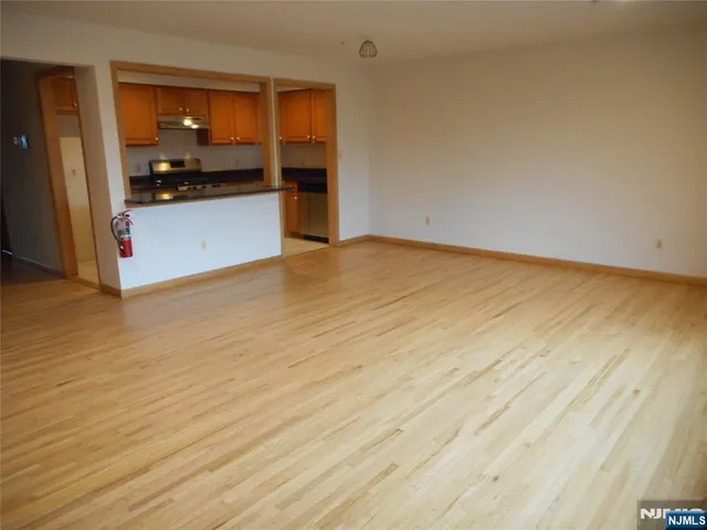 a view of a kitchen with wooden floor and cabinets