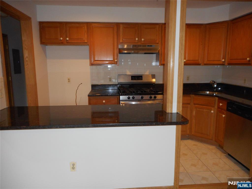 129 River Road, Unit 129 Clifton, NJ 07014 - Photo 6 of 21 a kitchen with stainless steel appliances granite countertop a stove a sink and a refrigerator