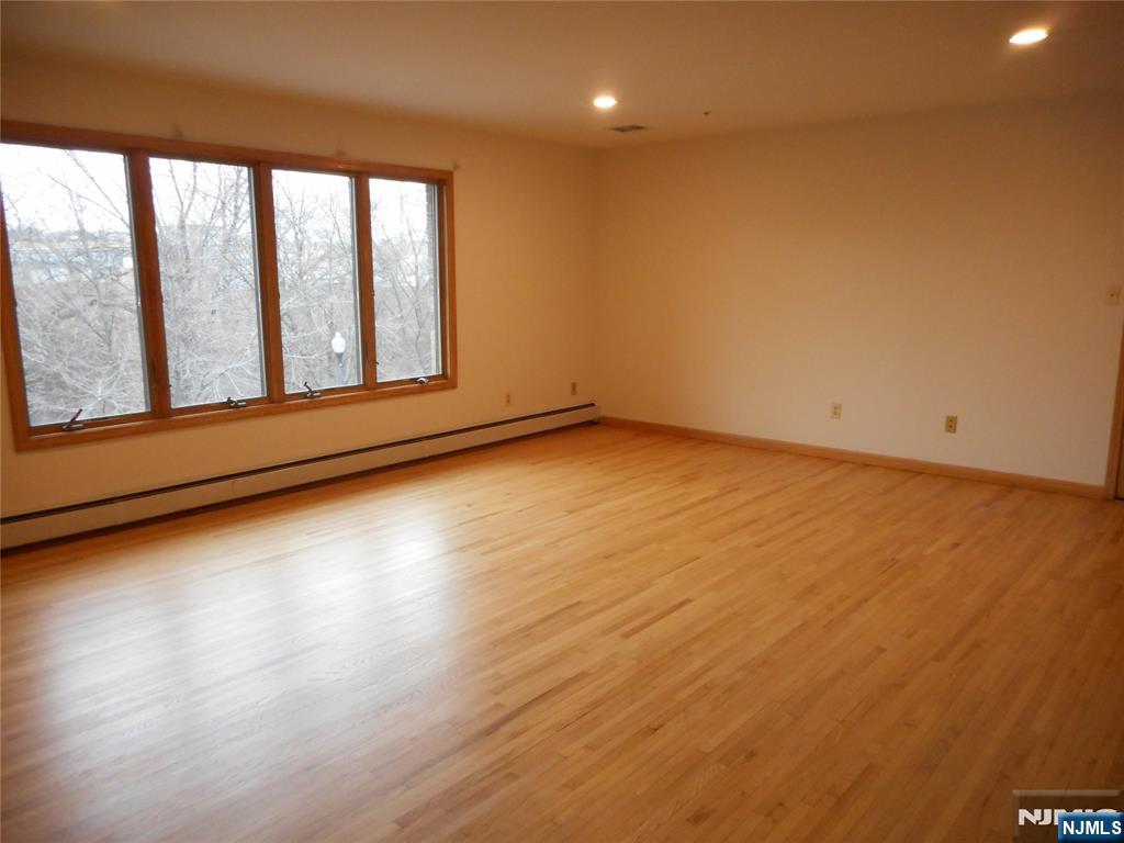 129 River Road, Unit 129 Clifton, NJ 07014 - Photo 7 of 21 a view of a room with wooden floor and window