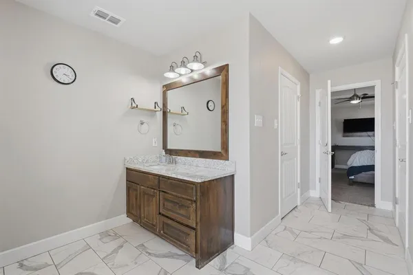 a bathroom with a granite countertop sink and a mirror