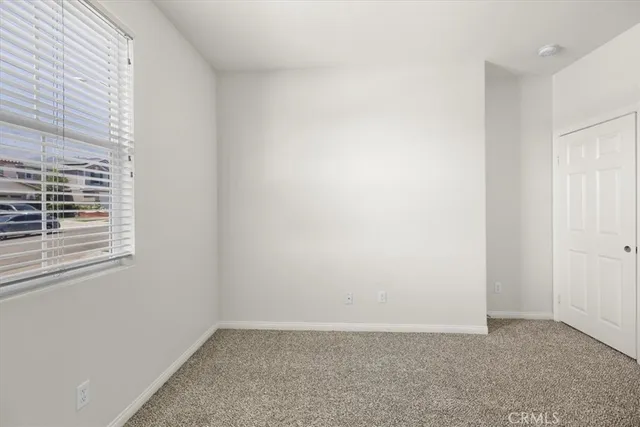an empty room with a window and a ceiling fan