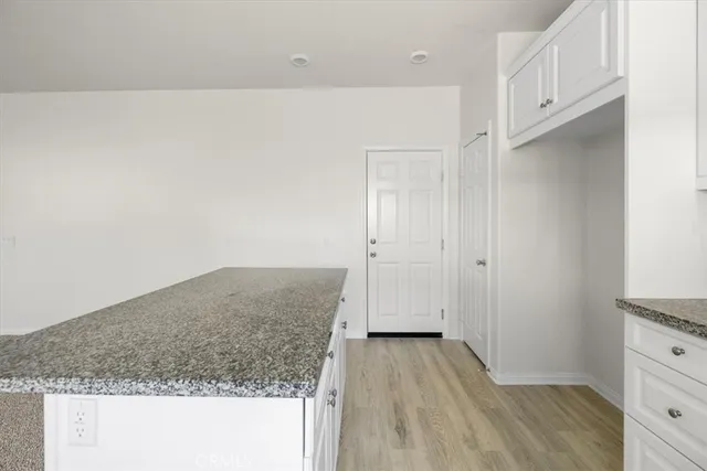 a kitchen with granite countertop white cabinets and white appliances