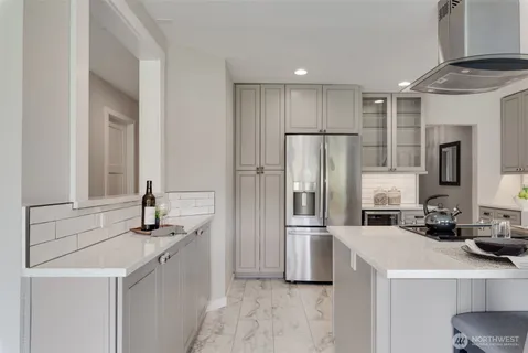 a dining room with stainless steel appliances kitchen island granite countertop a dining table chairs and a refrigerator