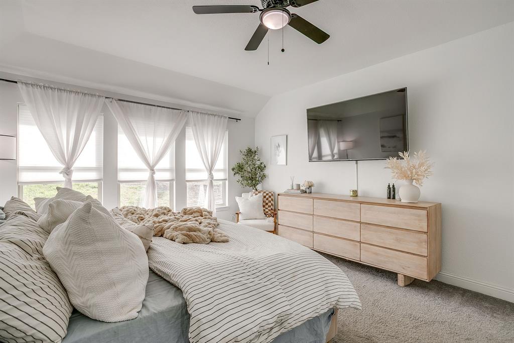 5617 Kilpatrick Avenue Fort Worth, TX 76107 - Photo 25 of 40 a spacious bedroom with a bed a window and a flat screen television