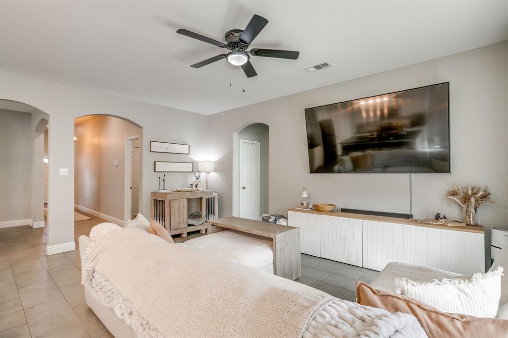 5617 Kilpatrick Avenue Fort Worth, TX 76107 - Photo 7 of 40 a living room with a bed a flat screen tv and a dresser