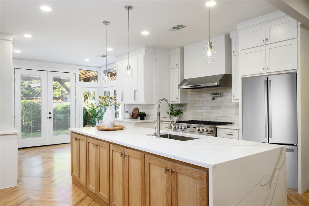 6021 Northwood Road Dallas, TX 75225 - Photo 12 of 40 a kitchen with stainless steel appliances kitchen island granite countertop a refrigerator a oven a sink and white cabinets with wooden floor