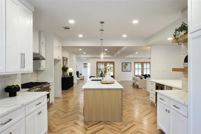 a large kitchen with sink stove and cabinets