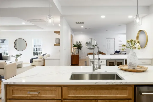 a kitchen with a stove a sink and a dining table with wooden floor