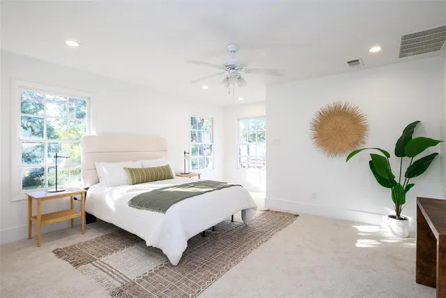 a bedroom with a large bed chandelier and a window