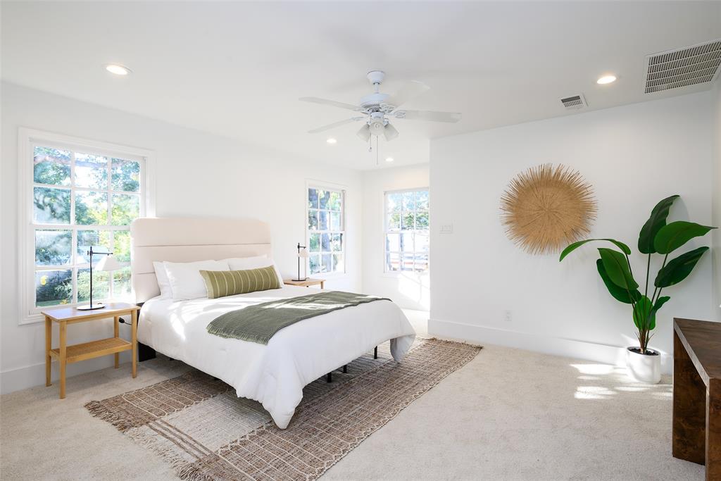 6021 Northwood Road Dallas, TX 75225 - Photo 19 of 40 a bedroom with a large bed chandelier and a window