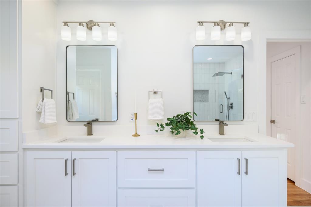 6021 Northwood Road Dallas, TX 75225 - Photo 28 of 40 a bathroom with double vanity sink and a mirror