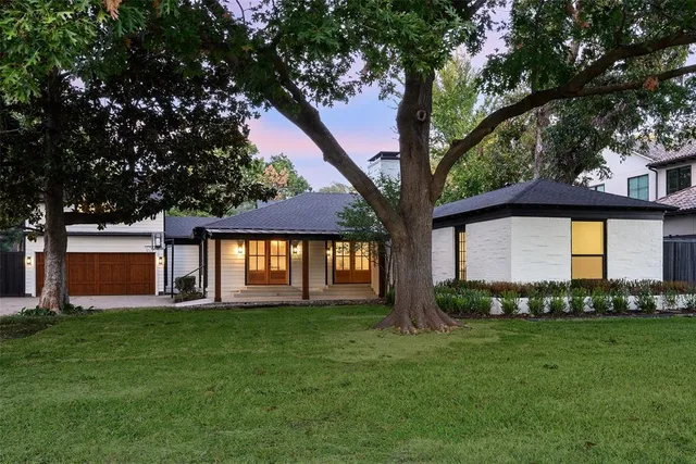 a front view of a house with a yard and trees
