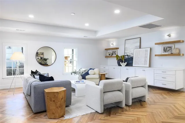 a living room with furniture a clock and a wooden floor