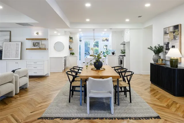 a living room with furniture a rug and kitchen view