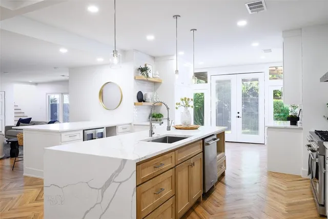 a kitchen with a sink stove and wooden floor