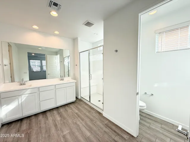 a large bathroom with a granite countertop sink a mirror and a toilet