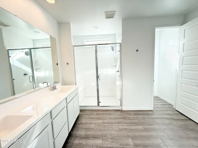 a spacious bathroom with a double vanity sink and a mirror