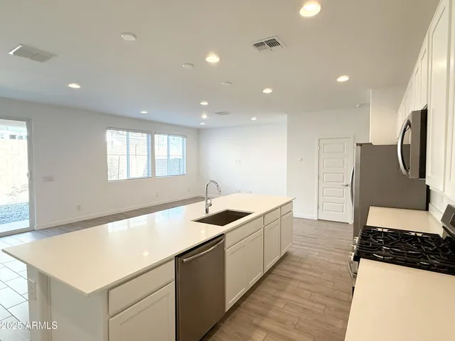 a kitchen with stainless steel appliances granite countertop a sink and a stove