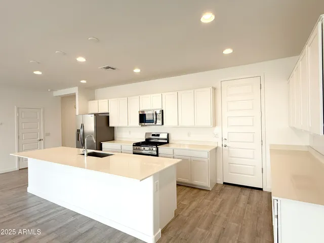 a kitchen with a sink a stove top oven a counter space and cabinets