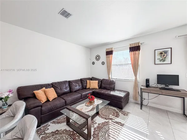 a living room with furniture and kitchen view