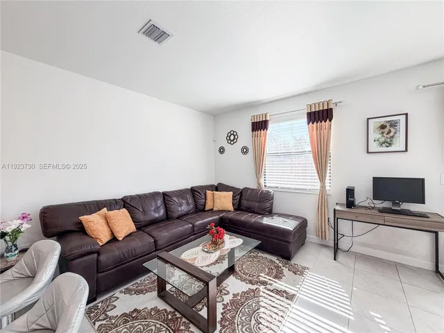 a living room with furniture and kitchen view