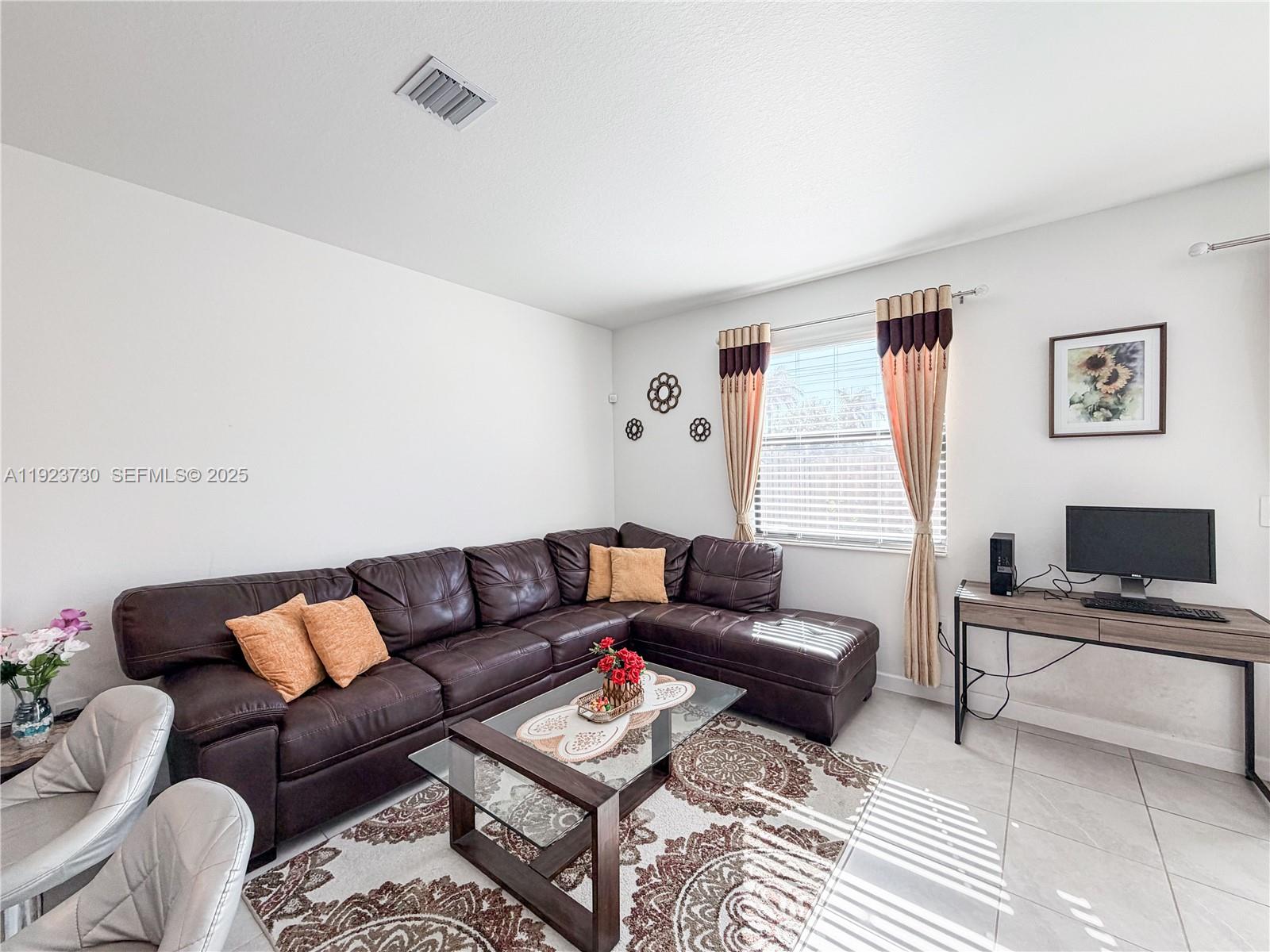 11962 Southwest 247th Terrace, Unit 11962 Homestead, FL 33032 - Photo 13 of 31 a living room with furniture and a window