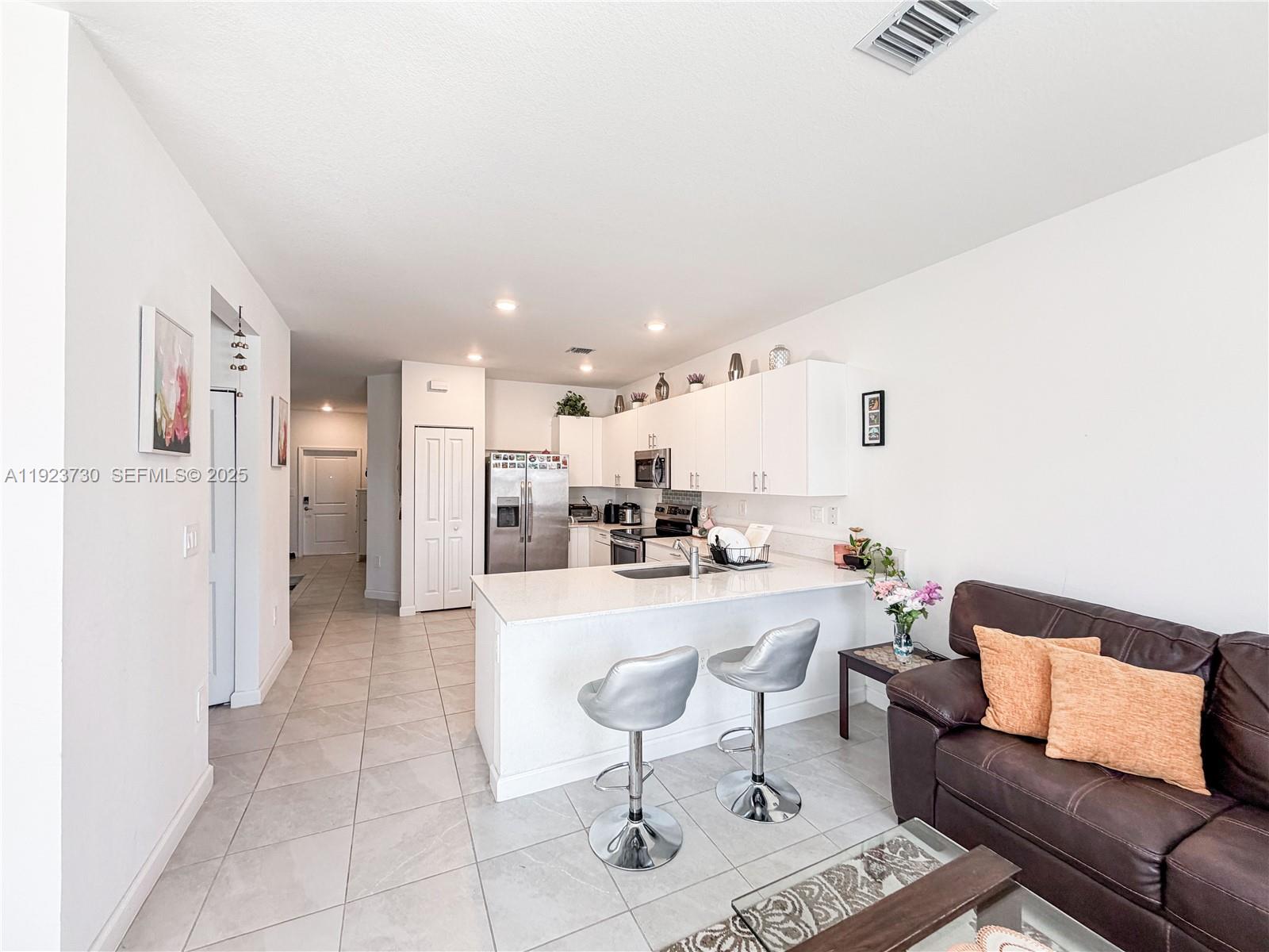 11962 Southwest 247th Terrace, Unit 11962 Homestead, FL 33032 - Photo 14 of 31 a living room with furniture and kitchen view