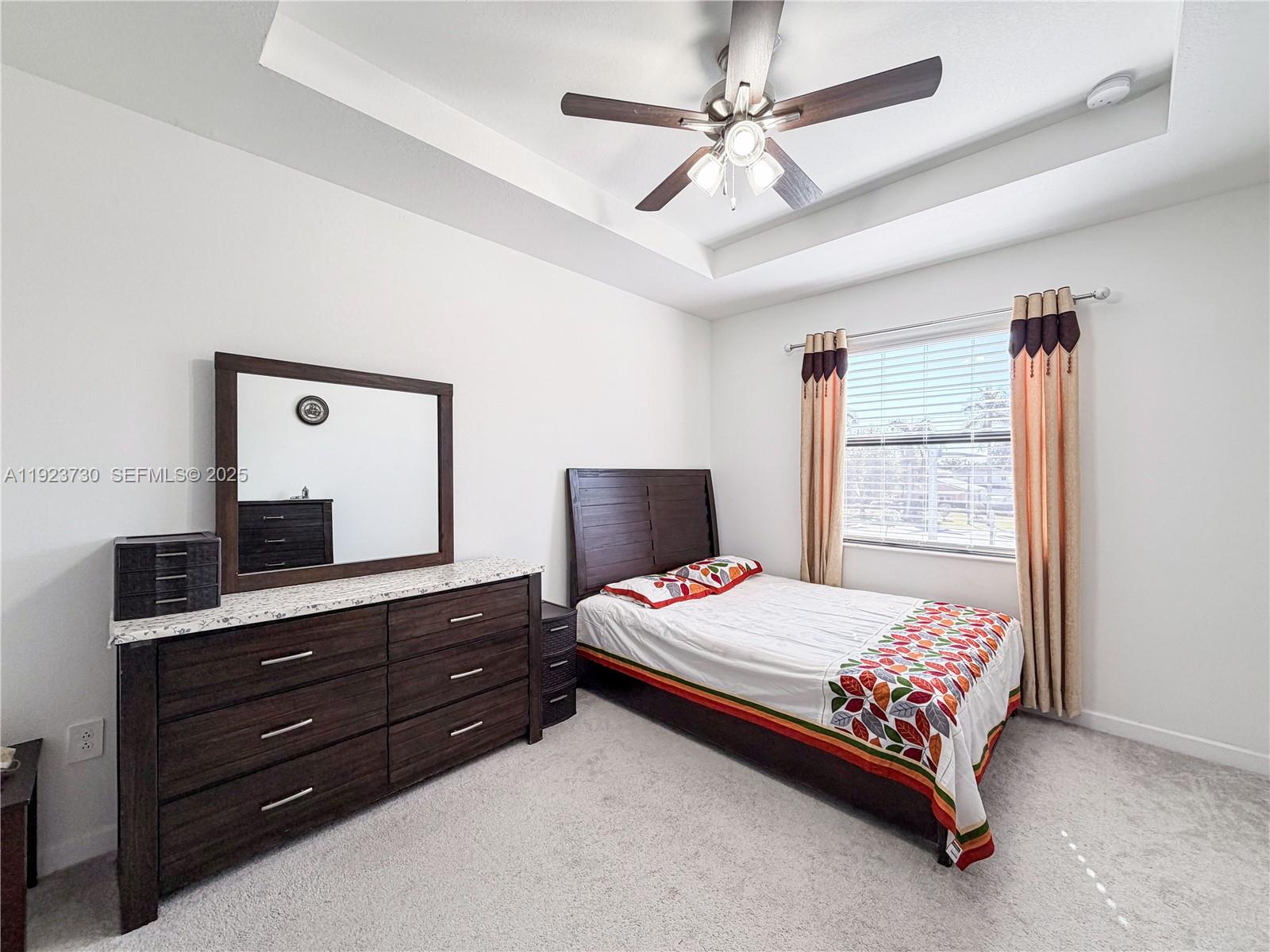 11962 Southwest 247th Terrace, Unit 11962 Homestead, FL 33032 - Photo 16 of 31 a bedroom with a bed and a mirror on dresser