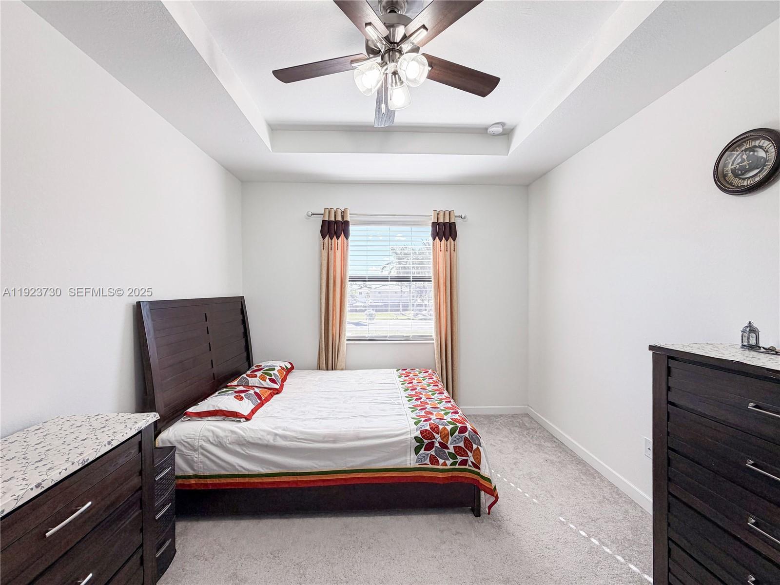 11962 Southwest 247th Terrace, Unit 11962 Homestead, FL 33032 - Photo 17 of 31 a bedroom with a bed and a chandelier