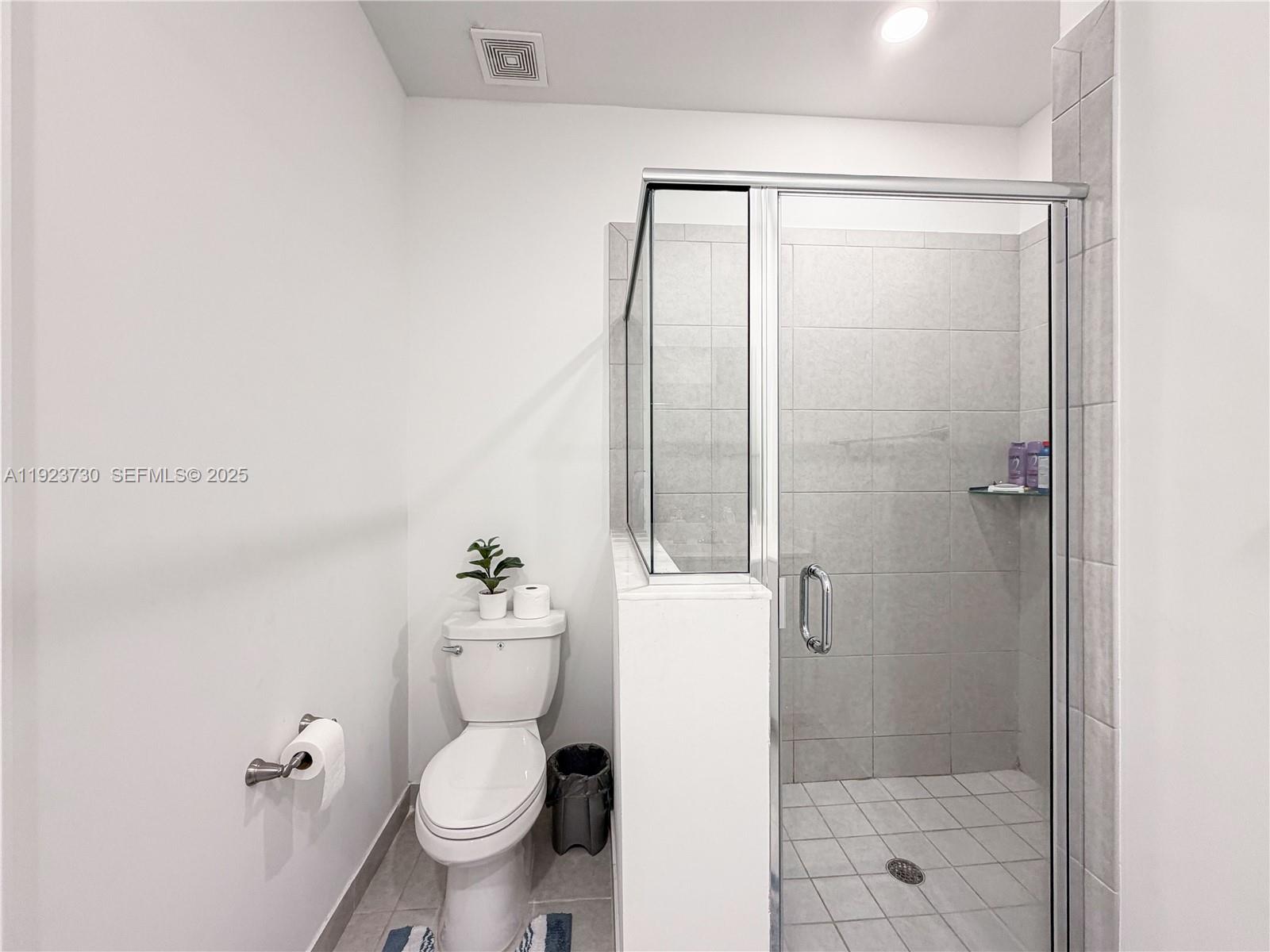 11962 Southwest 247th Terrace, Unit 11962 Homestead, FL 33032 - Photo 18 of 31 a bathroom with a granite countertop toilet a sink and a shower