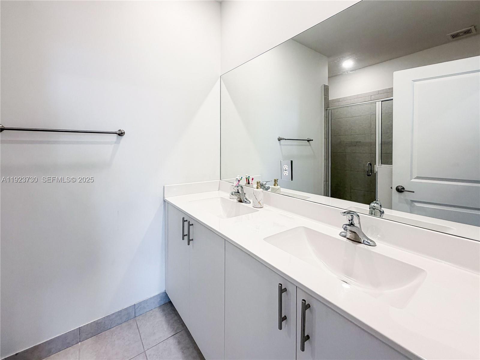 11962 Southwest 247th Terrace, Unit 11962 Homestead, FL 33032 - Photo 19 of 31 a bathroom with a sink and a mirror