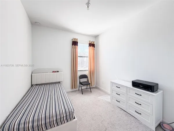 a large bed sitting in a bedroom next to a window