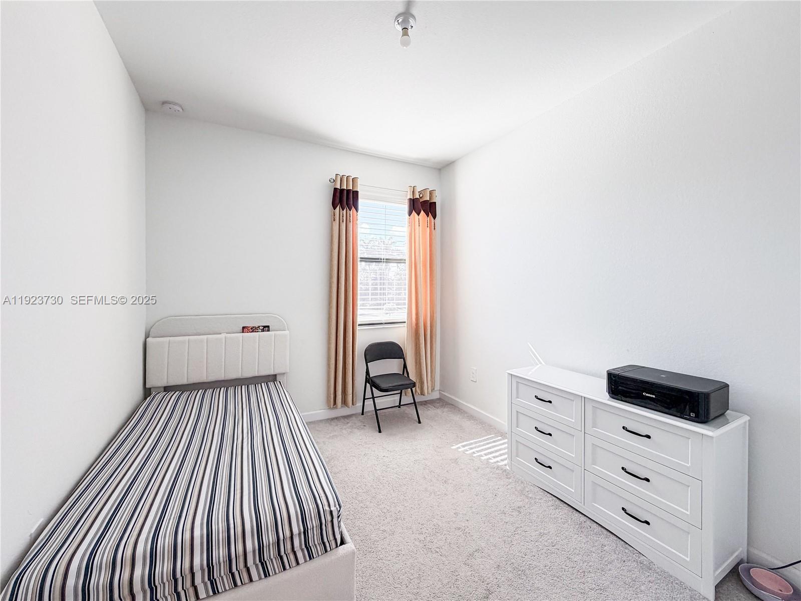 11962 Southwest 247th Terrace, Unit 11962 Homestead, FL 33032 - Photo 20 of 31 a view of a bedroom with furniture and windows