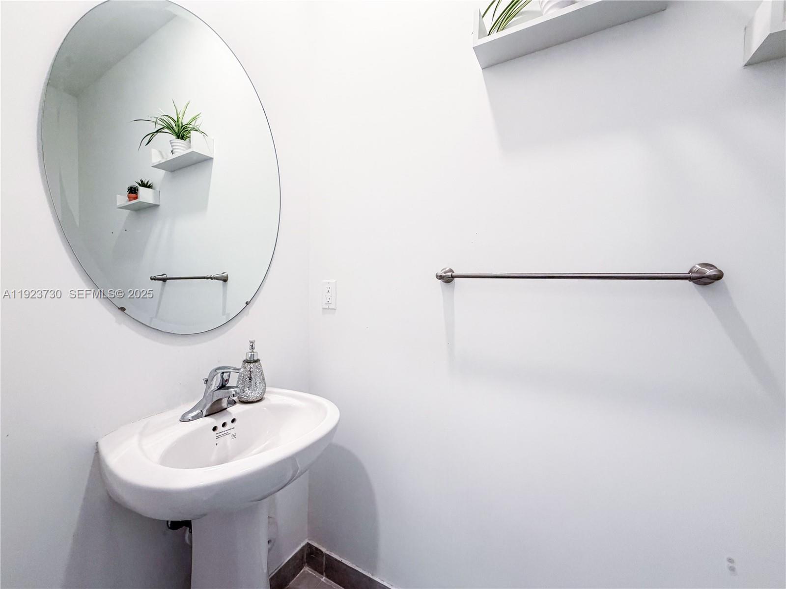 11962 Southwest 247th Terrace, Unit 11962 Homestead, FL 33032 - Photo 27 of 31 a bathroom with a sink a mirror and a shower