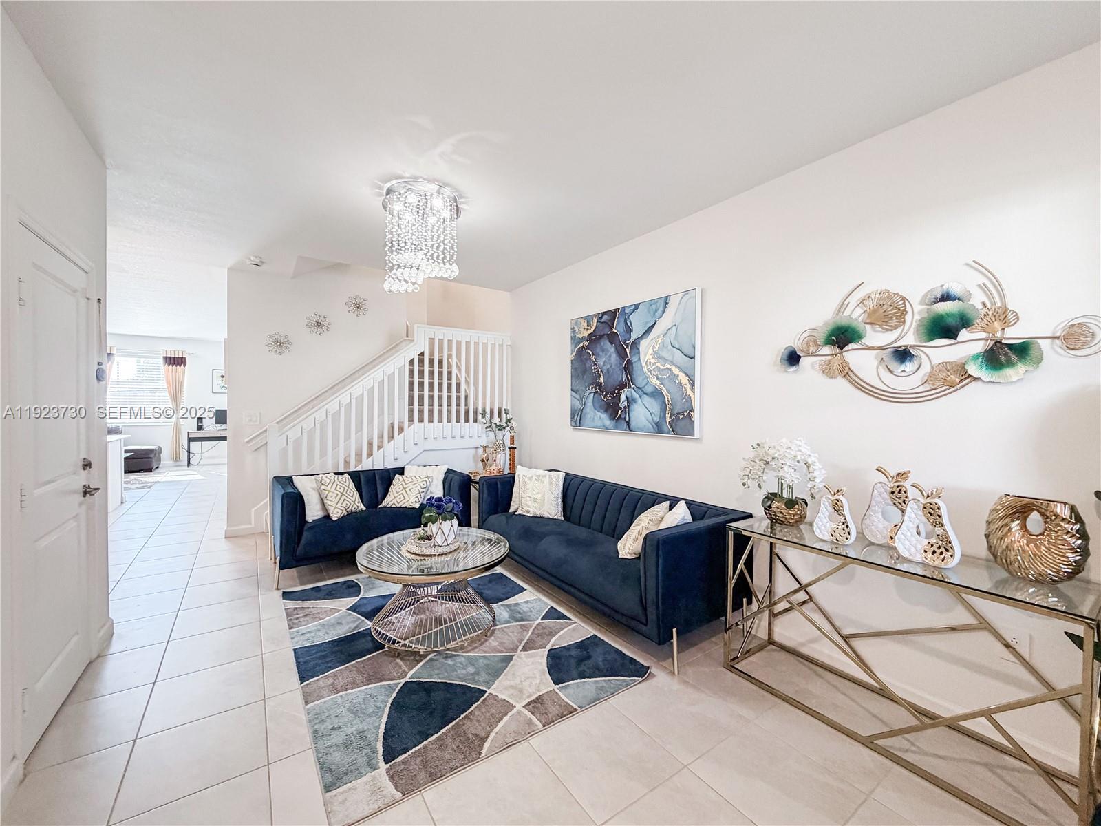 11962 Southwest 247th Terrace, Unit 11962 Homestead, FL 33032 - Photo 6 of 31 a living room with furniture a rug and white walls