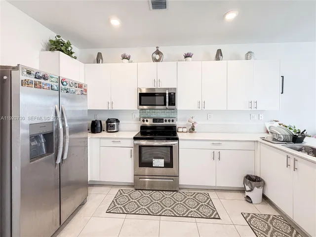 a kitchen with stainless steel appliances a stove sink and cabinets