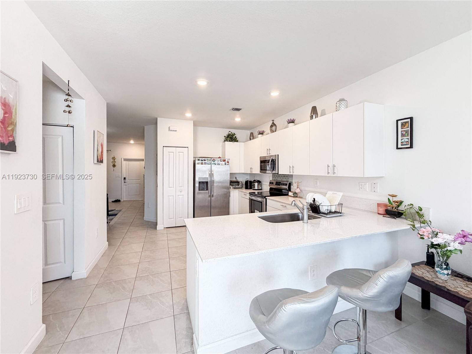 11962 Southwest 247th Terrace, Unit 11962 Homestead, FL 33032 - Photo 9 of 31 a kitchen with stainless steel appliances kitchen island granite countertop a refrigerator and a sink