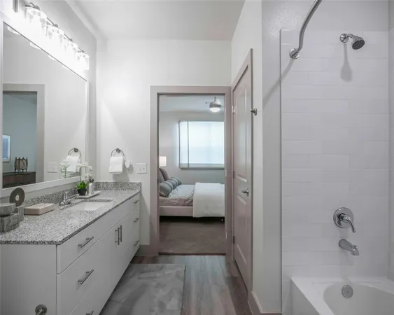 a en suite bathroom with a granite countertop tub sink and shower