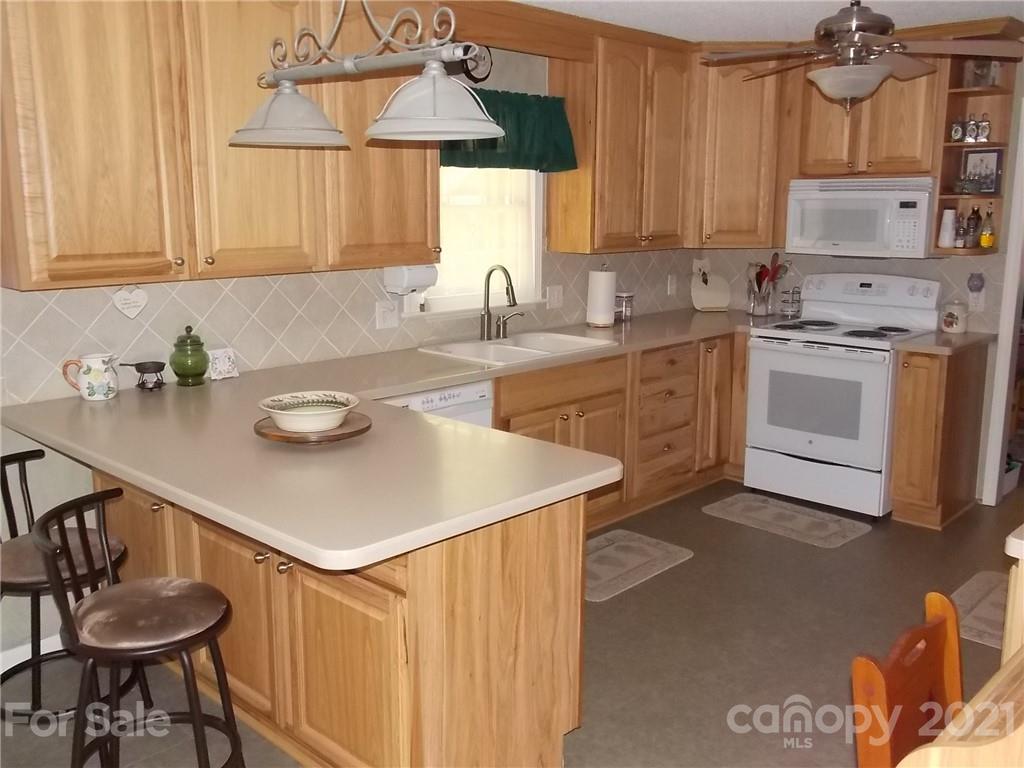 1766 Williams Road Fort Mill, SC 29715 - Photo 14 of 32 a kitchen with stainless steel appliances granite countertop a sink a stove and white cabinets