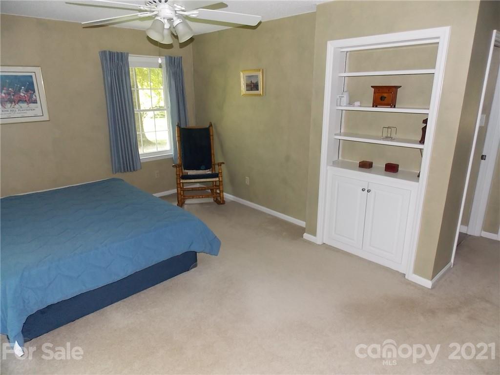 1766 Williams Road Fort Mill, SC 29715 - Photo 22 of 32 a bedroom with a bed and a chandelier