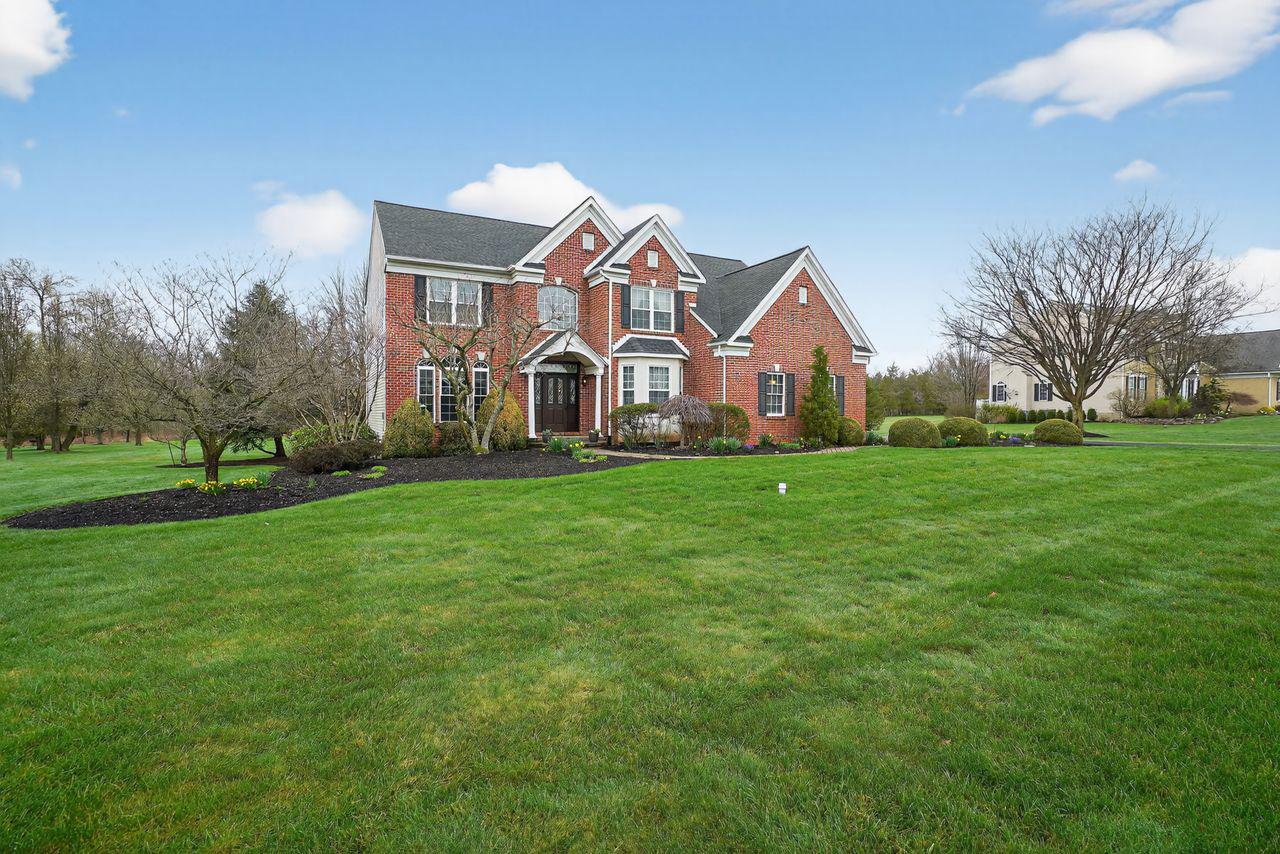 Striking brick home on lush grounds.